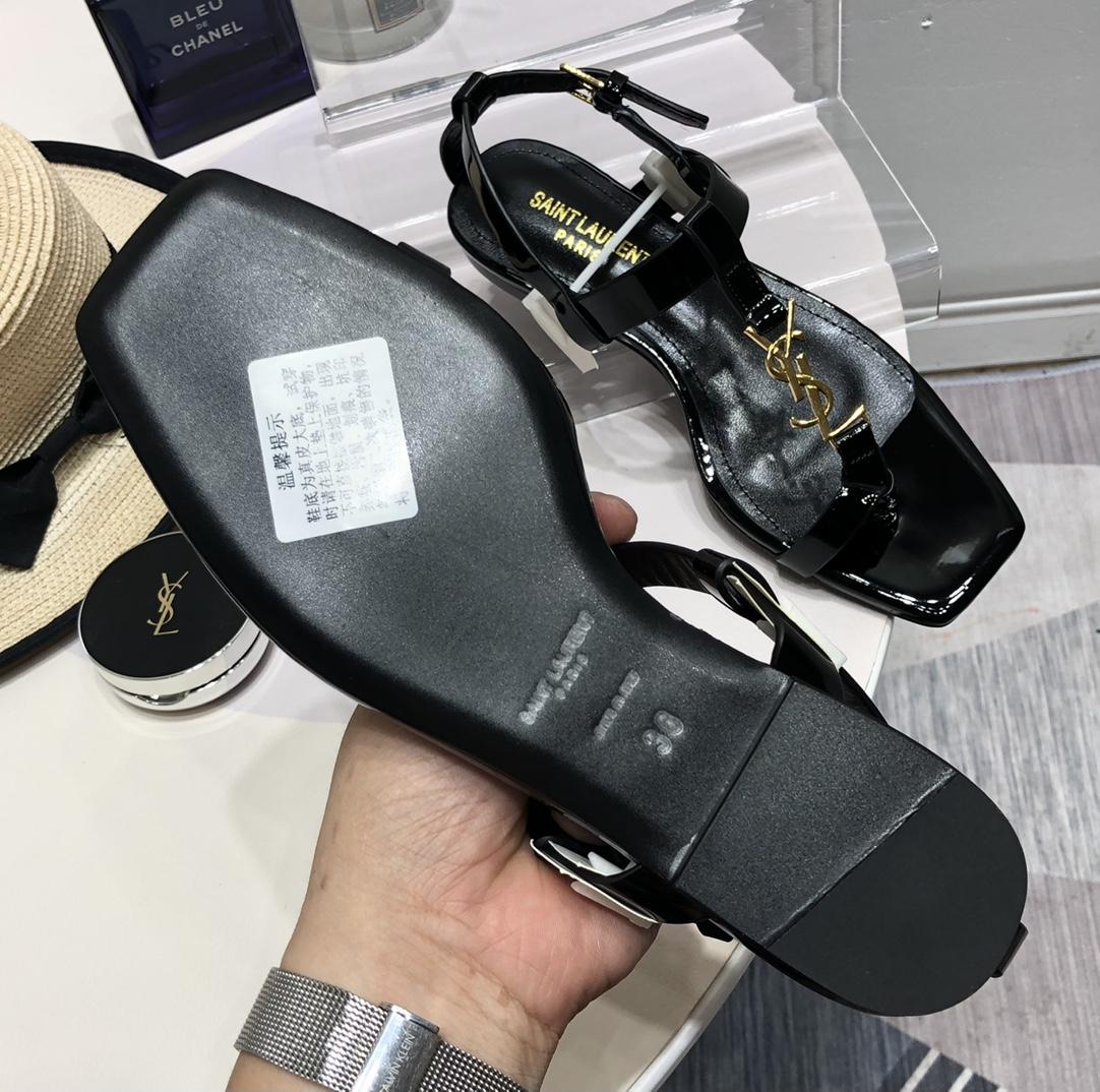Saint Laurent Cassandra Flat Sandals In Patent Leather With Gold-Tone Monogram - FashionPlug