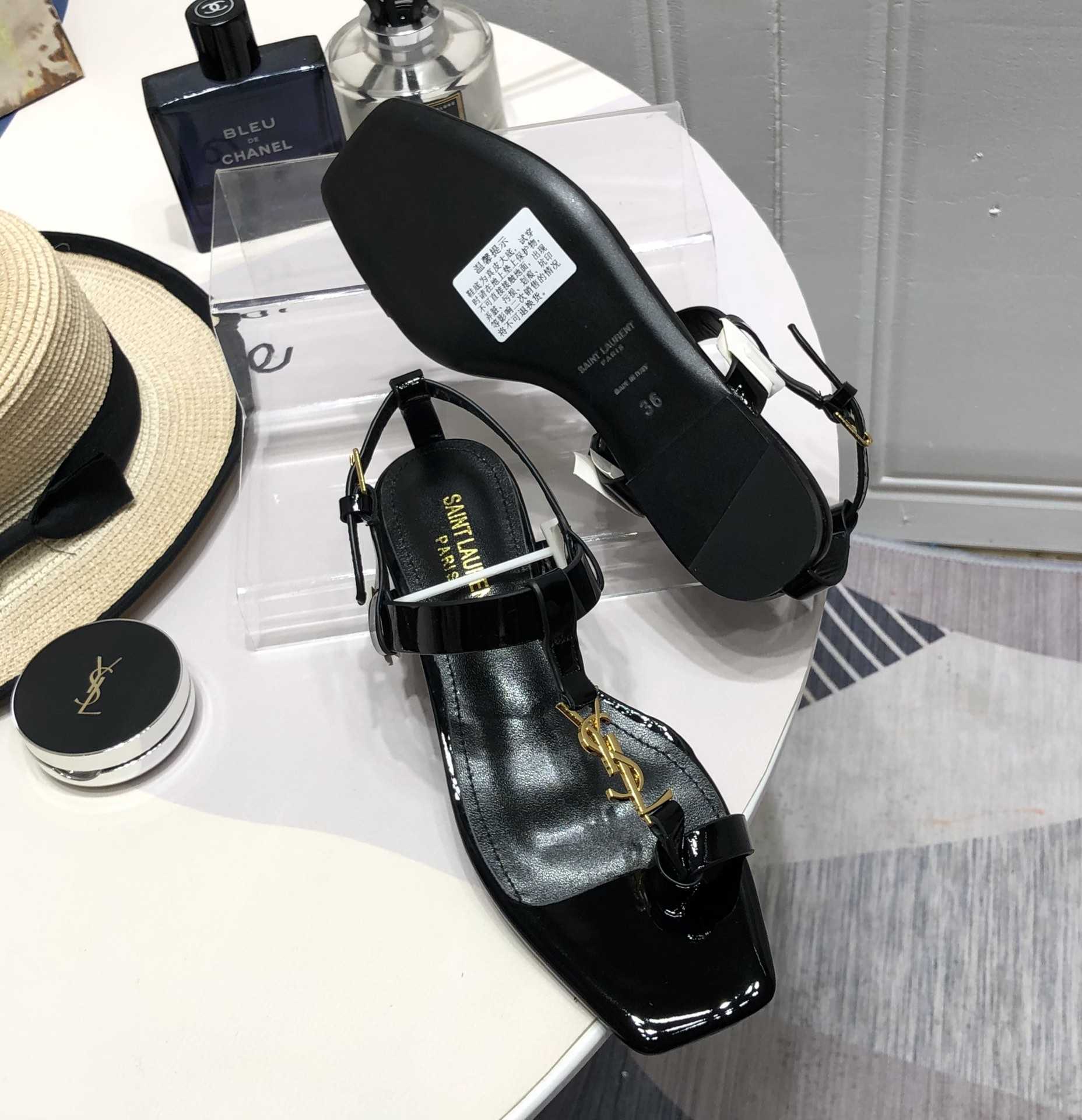 Saint Laurent Cassandra Flat Sandals In Patent Leather With Gold-Tone Monogram - FashionPlug