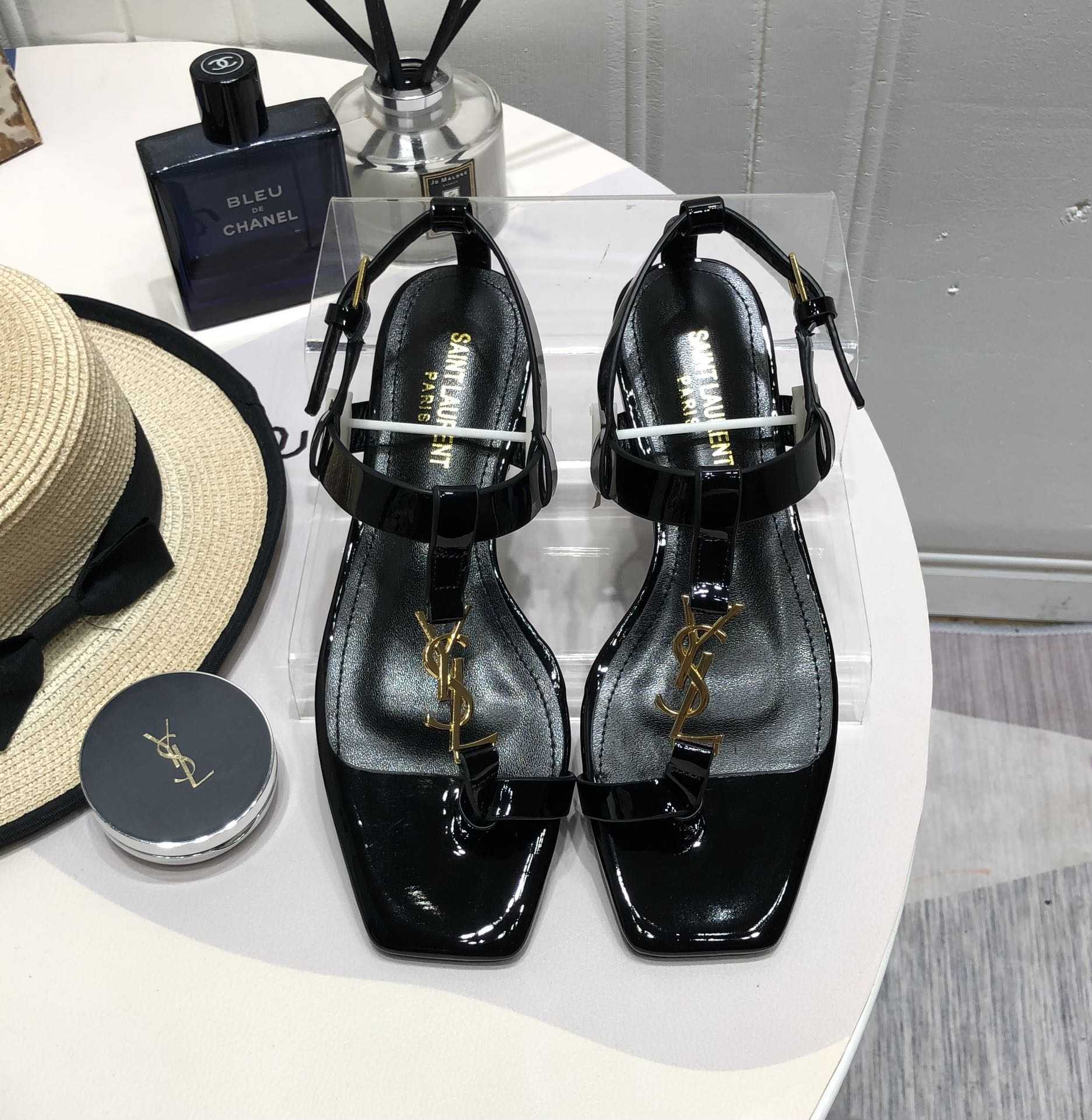 Saint Laurent Cassandra Flat Sandals In Patent Leather With Gold-Tone Monogram - FashionPlug