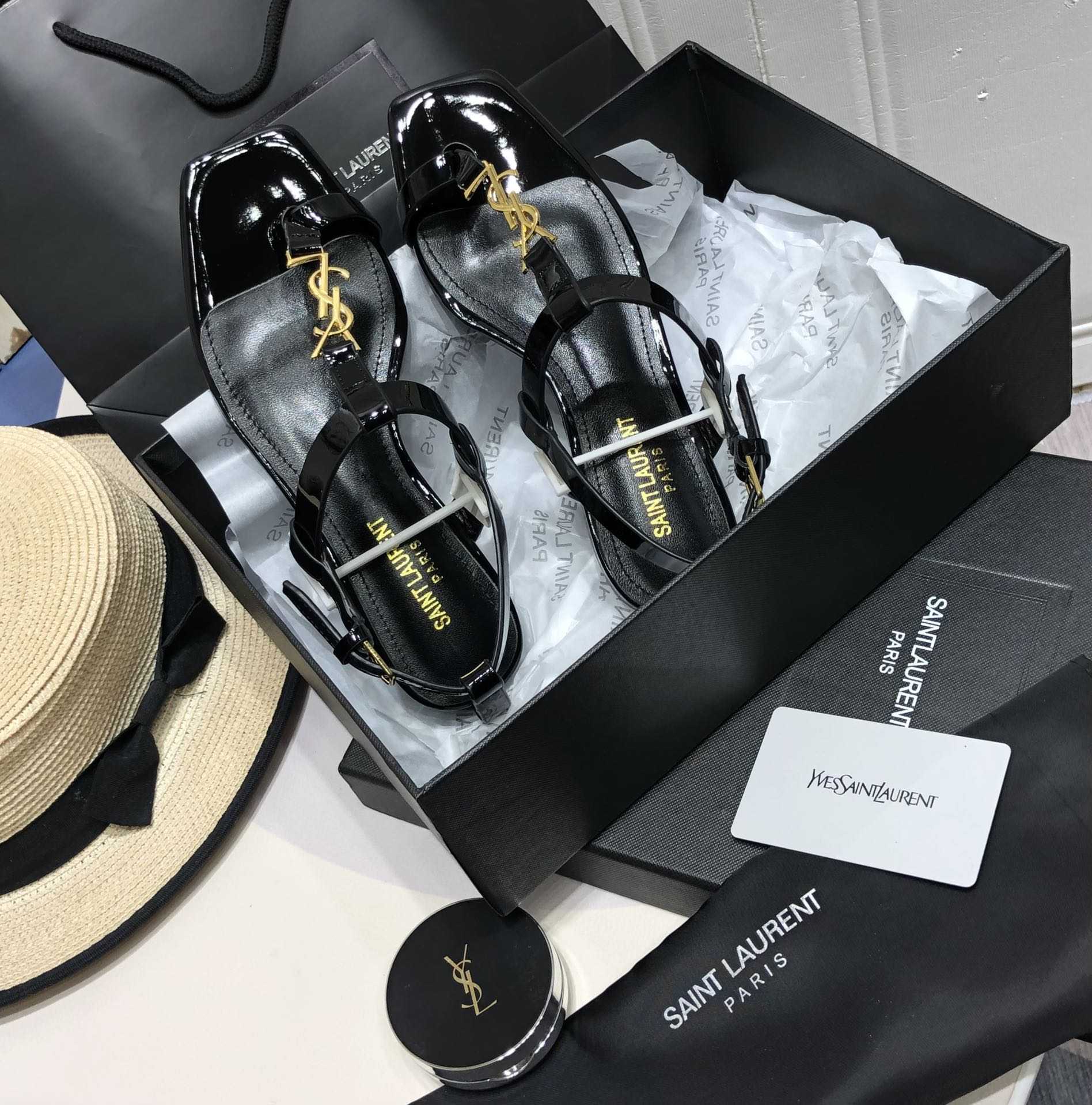 Saint Laurent Cassandra Flat Sandals In Patent Leather With Gold-Tone Monogram - FashionPlug
