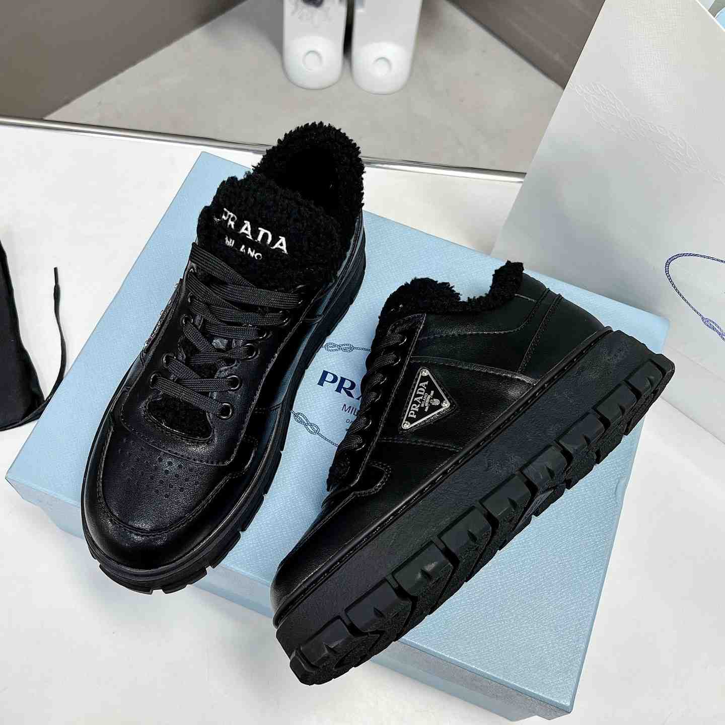 Prada Leather And Shearling Sneakers - FashionPlug