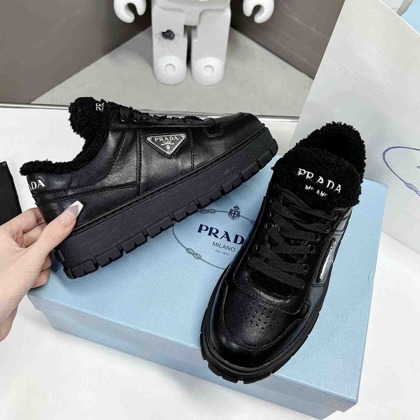 Prada Leather And Shearling Sneakers - FashionPlug