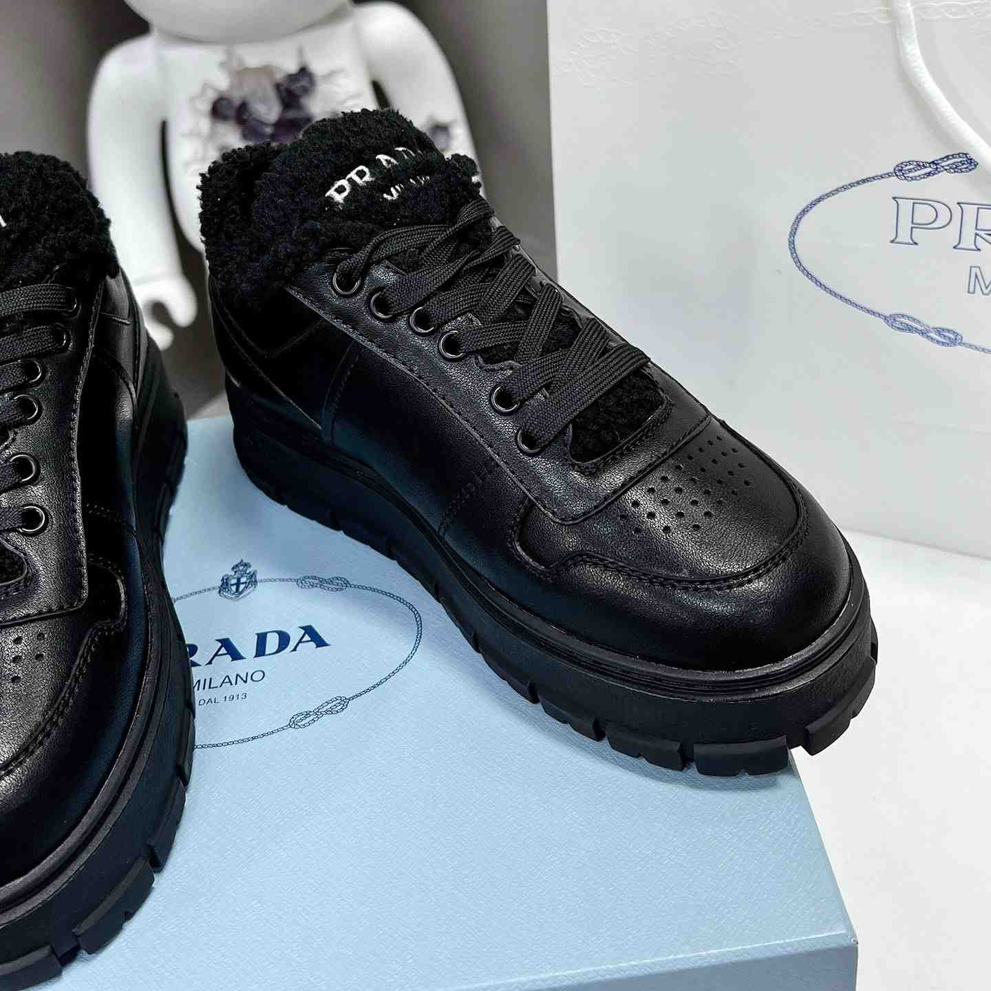 Prada Leather And Shearling Sneakers - FashionPlug