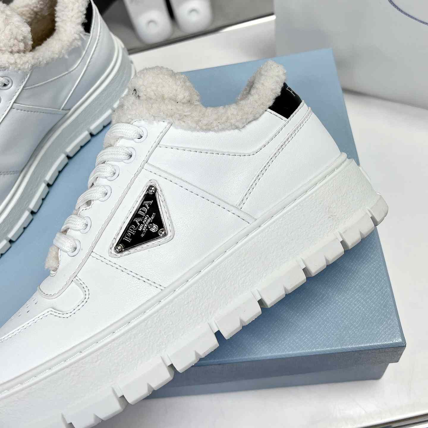 Prada Leather And Shearling Sneakers - FashionPlug