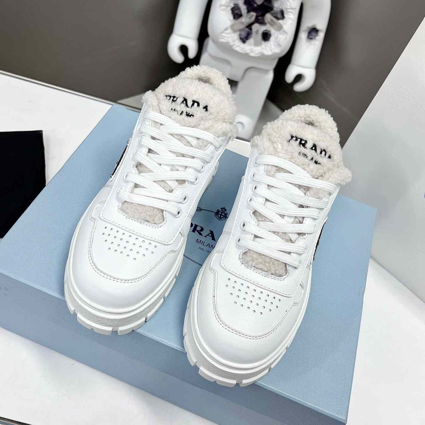 Prada Leather And Shearling Sneakers - FashionPlug