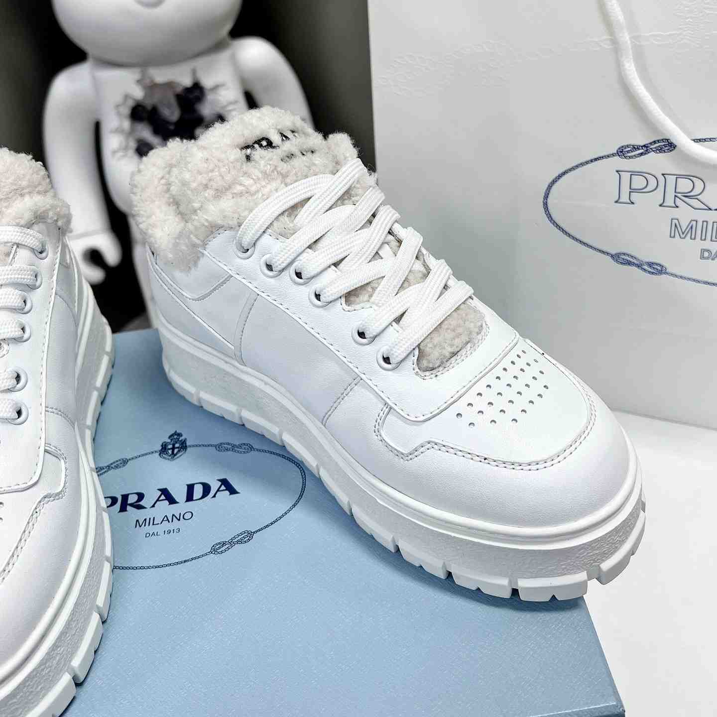 Prada Leather And Shearling Sneakers - FashionPlug