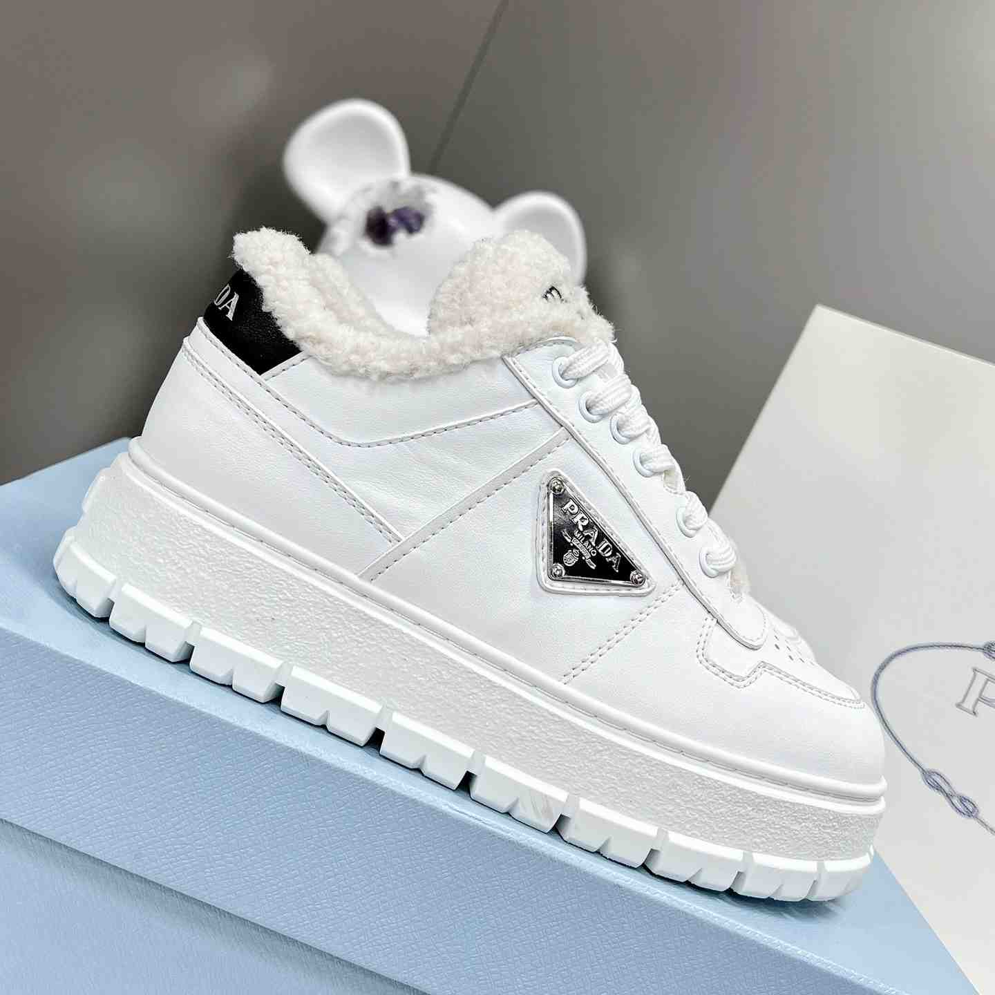 Prada Leather And Shearling Sneakers - FashionPlug