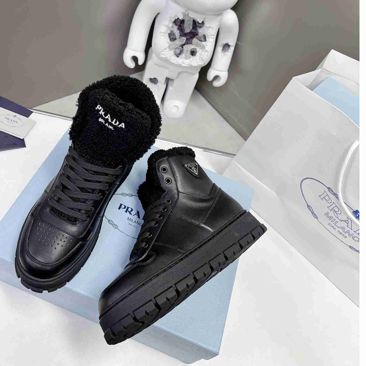 Prada Leather And Shearling High-top Sneakers - FashionPlug