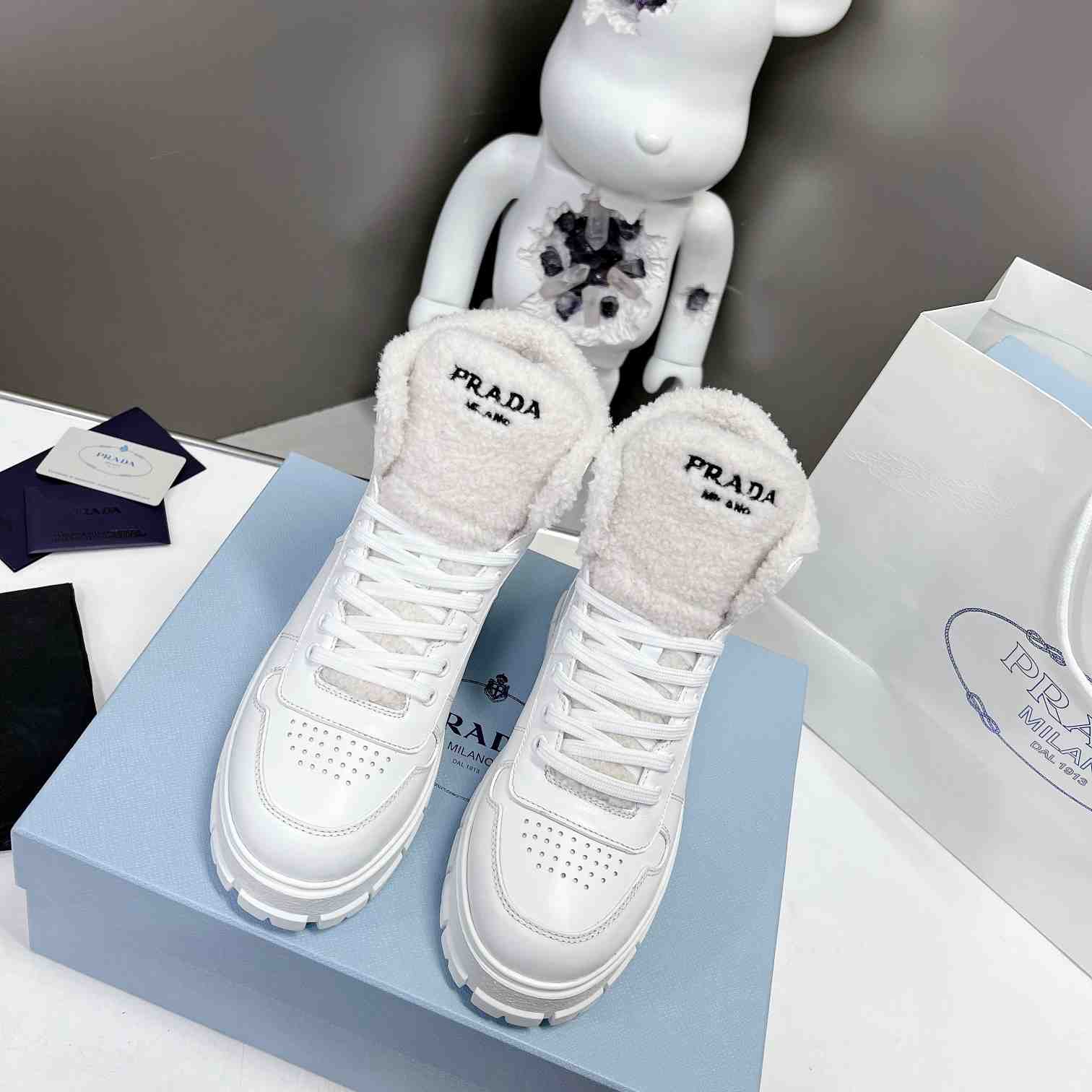 Prada Leather And Shearling High-top Sneakers - FashionPlug