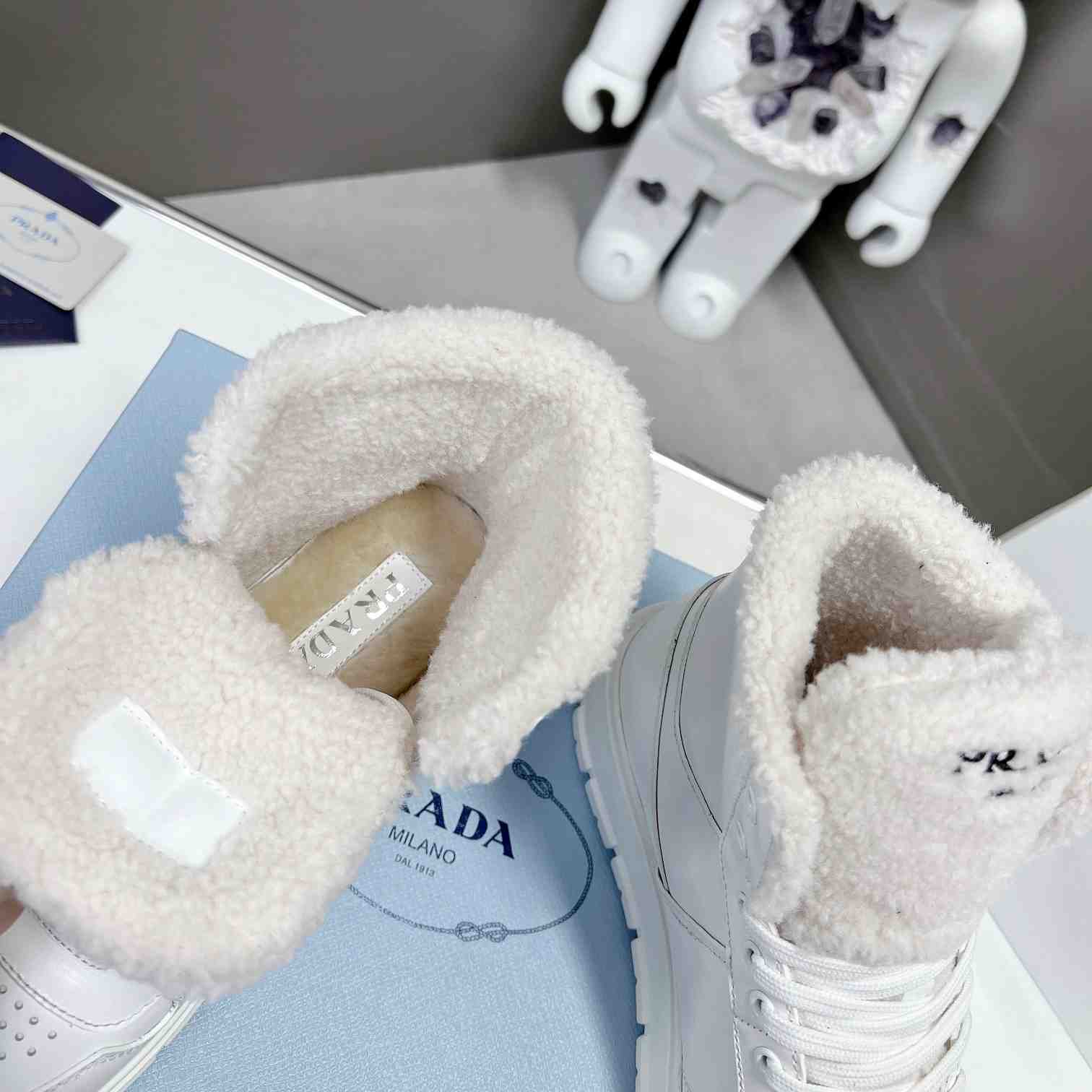 Prada Leather And Shearling High-top Sneakers - FashionPlug